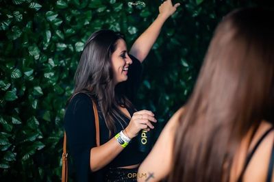 Happy young woman with arms raised