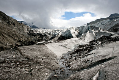 Scenic view of mountains against cloudy sky