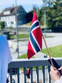 Midsection of man holding norwegian flag