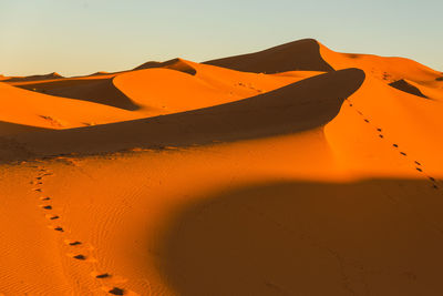 Scenic view of desert against sky during sunset