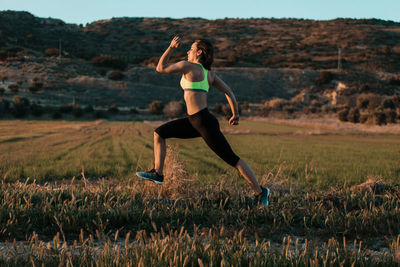 Full length of woman with running on field