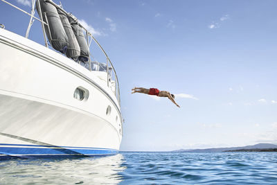 Man jumping off his motor yacht
