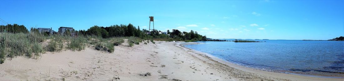 Scenic view of beach against blue sky