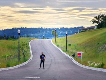 Alone man on the road against sky during sunset 