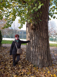 Man standing by tree in park during autumn