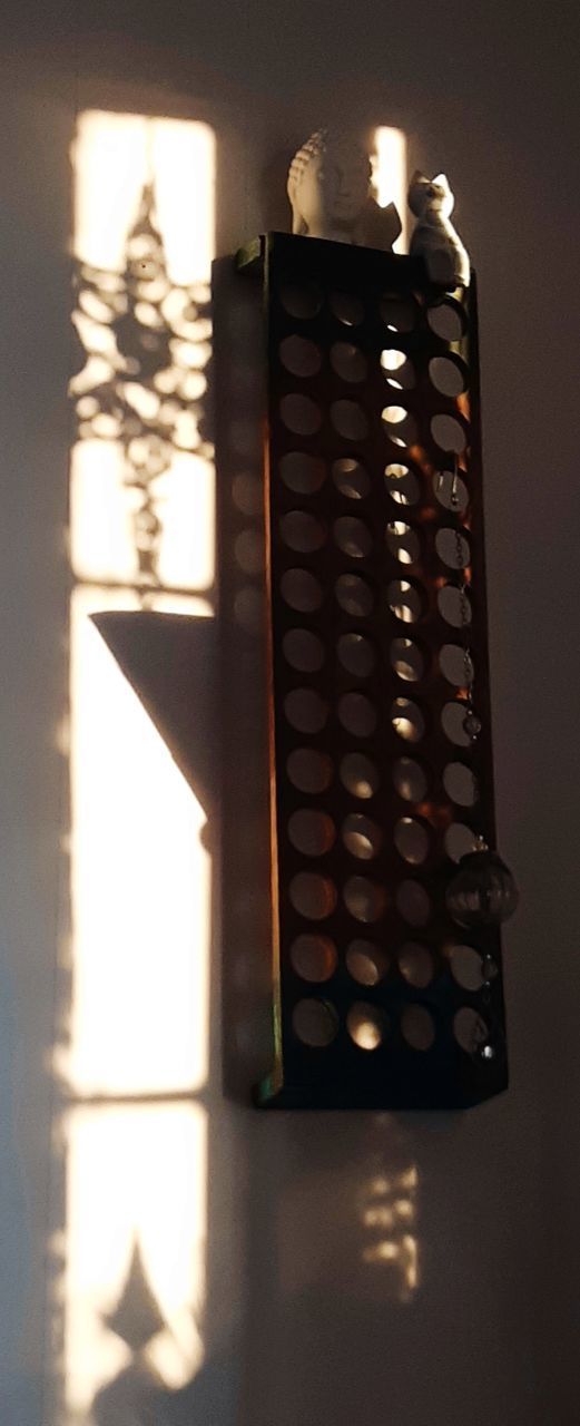 CLOSE-UP OF ILLUMINATED CANDLES ON WALL