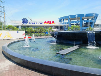 Water fountain in swimming pool against sky