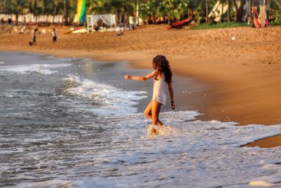 Full length of girl playing on beach