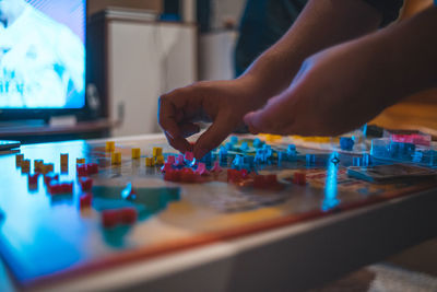 Cropped hands of woman playing game at home