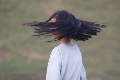 Side view of woman flying against blurred background