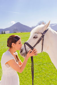 Young woman kissing horse