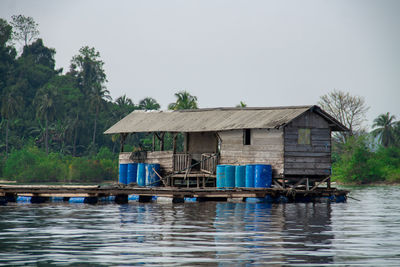 House by river against clear sky