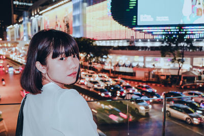 Portrait of woman in city at night