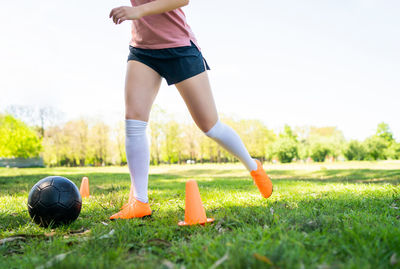 Low section of woman playing soccer on field