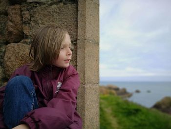 Side view of girl looking away against sky