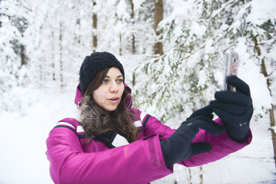 Woman using mobile phone during winter