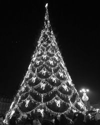 Low angle view of illuminated christmas tree against sky at night