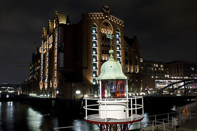 Low angle view of illuminated buildings against sky at night