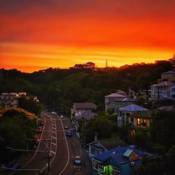 Cars on road against sky during sunset