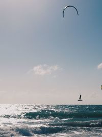Scenic view of sea against sky woth kiteboarder