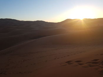 Scenic view of desert against sky during sunset