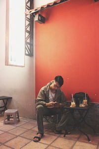 Man looking at camera while sitting on table at home