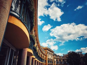 Low angle view of buildings against cloudy sky