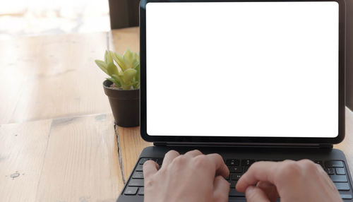 Midsection of man using mobile phone on table