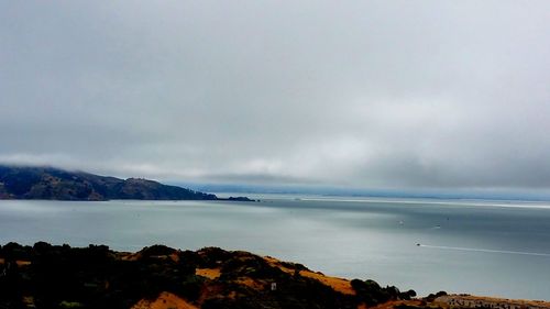 Scenic view of mountains against cloudy sky