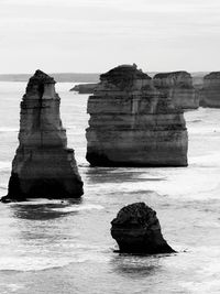 Rocks on sea shore against sky