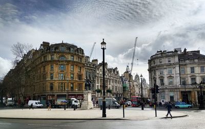 Buildings in city against cloudy sky