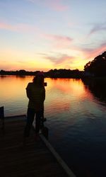 Silhouette of people standing on pier