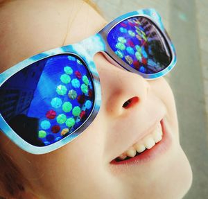 Close-up of smiling cute girl wearing sunglasses