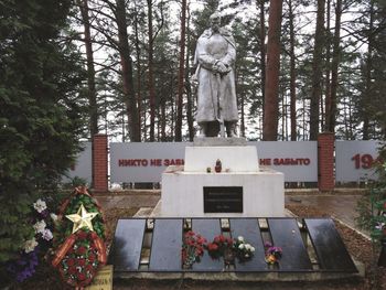 Statue against trees at cemetery