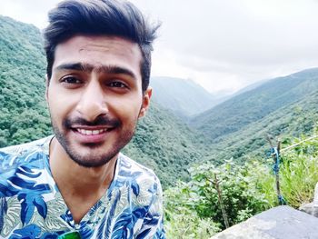 Portrait of young man against mountains