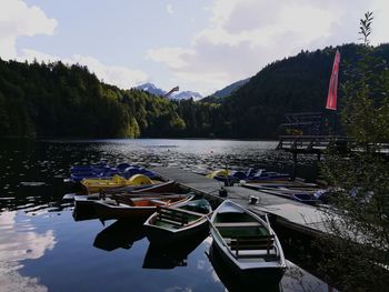 Boats moored on lake against sky