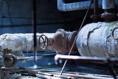 Close-up of weathered metallic pipe in abandoned factory