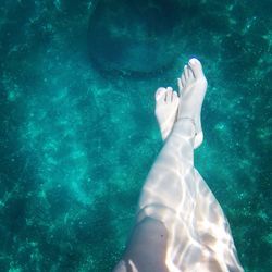 Low section of woman swimming in swimming pool