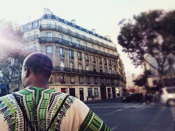 Rear view of woman standing in front of building