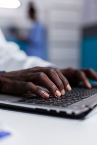 Midsection of person using mobile phone on table