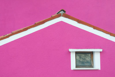 Low angle view of pink building against sky