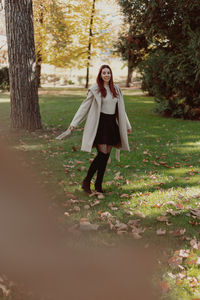 Full length of woman standing in forest