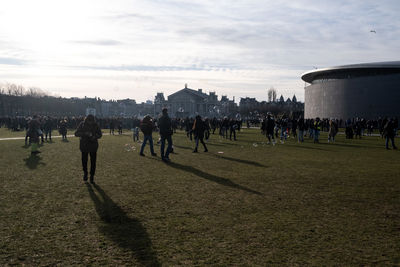 Group of people on field against buildings