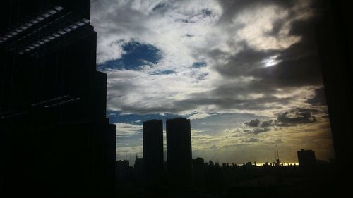 View of cityscape against cloudy sky