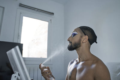 Portrait of young man looking at window at home