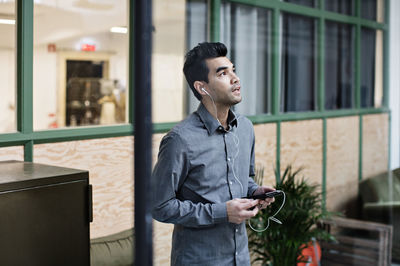 Man looking away while standing on mobile phone