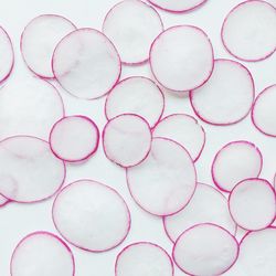 Full frame shot of radish slices on white background