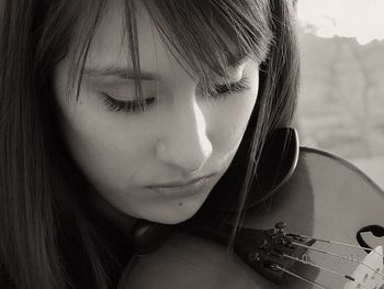 Close-up of young woman playing violin