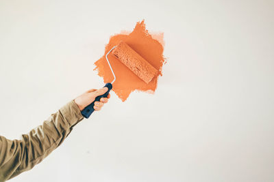 Cropped hand of woman holding gift against white background