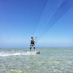 Man surfing in sea against clear sky
